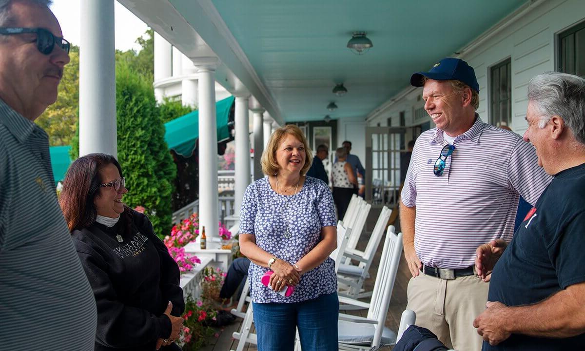 People talking on a covered balcony